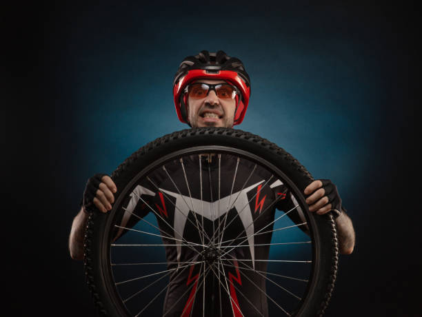 istock guy-cyclist in a Bicycle helmet with a Bicycle wheel 1203771974