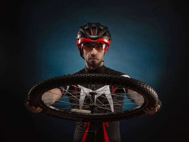 istock guy-cyclist in a Bicycle helmet with a Bicycle wheel 1203771978