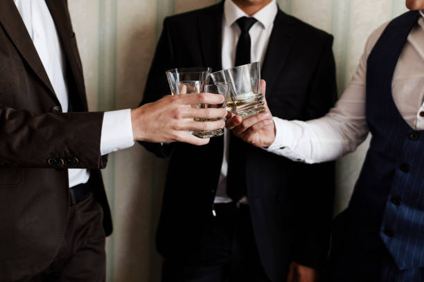 stylish friends businessmen in suits toasting with glasses of whiskey indoors, closeup. groom's morning stylish friends businessmen in suits toasting with glasses of whiskey indoors, closeup. groom's morning. stag night stock pictures, royalty-free photos & images