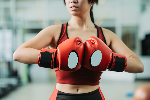 Young athletic female teenager having a boxing training