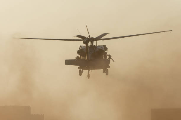 군사 헬기는 연기와 혼란과 파괴로 비행 전투와 전쟁에서 이륙한다. 힘, 힘, 힘, 공습의 군사 개념. 세로 보기입니다. - support horizontal war afghanistan 뉴스 사진 이미지