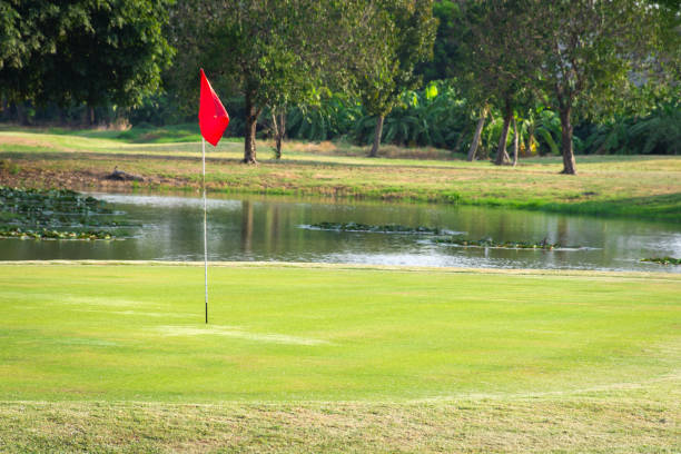 istock Red flag in the beautiful golf course and pond. 1203774240