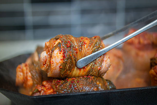 un plat fait en roulant le kimchi sur le ventre de porc. - barbecue grill broiling barbecue vegetable photos et images de collection