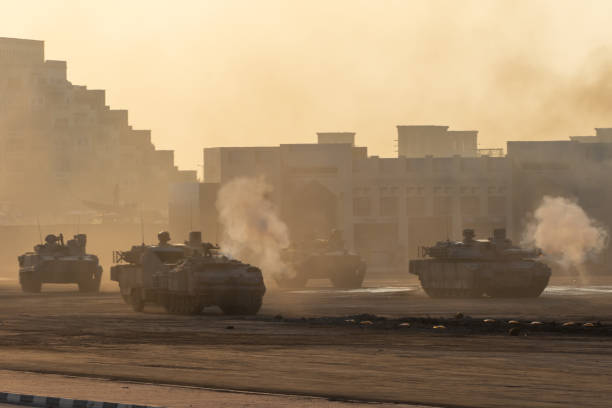 serie de tanques del ejército disparando y conduciendo en la ciudad desértica en la guerra y el conflicto militar. concepto militar de guerra y explosiones. - war crimes fotografías e imágenes de stock