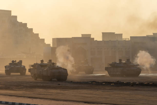 Series of Army tanks shooting and driving in the desert town in war and military conflict. Military concept of war and explosions. stock photo