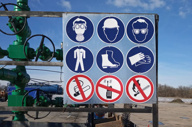 señales obligatorias están en la valla pozo de gas - safety sign protective workwear factory fotografías e imágenes de stock