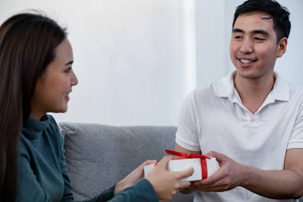 istock Man surprises his girlfriend with gift box. 1203776031