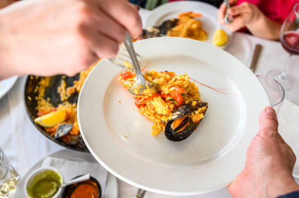 Spanish paella with seafood served in a pan. Fresh Shrimp, Scampi, mussels, squid, octopus and scallops. Top view. Selective focus. Restaurant