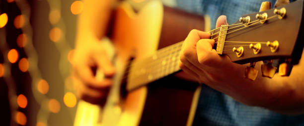 homme jouant une guitare acoustique pendant un concert - country music photos et images de collection