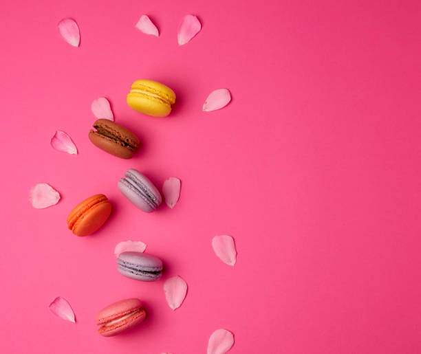 istock sweet multi-colored macarons with cream and a pink rose bud 1203778861