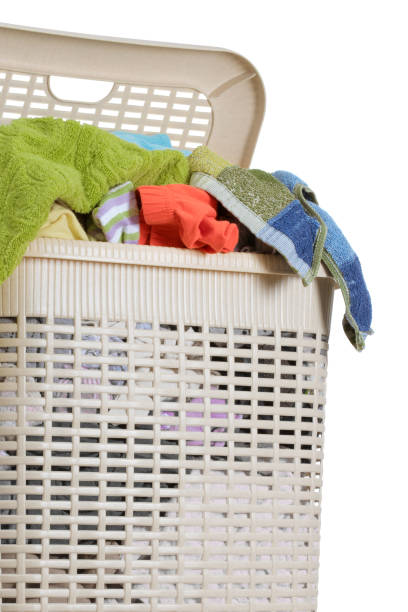 istock Laundry basket full of dirty washing (isolated on white) 1203780689