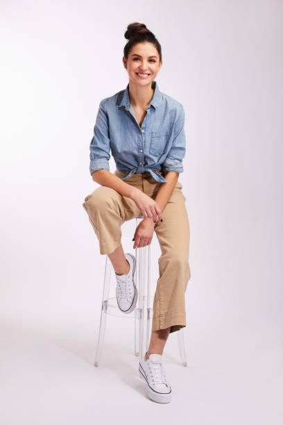 istock Young brunette woman smiling while sitting against a gray background 1203783453