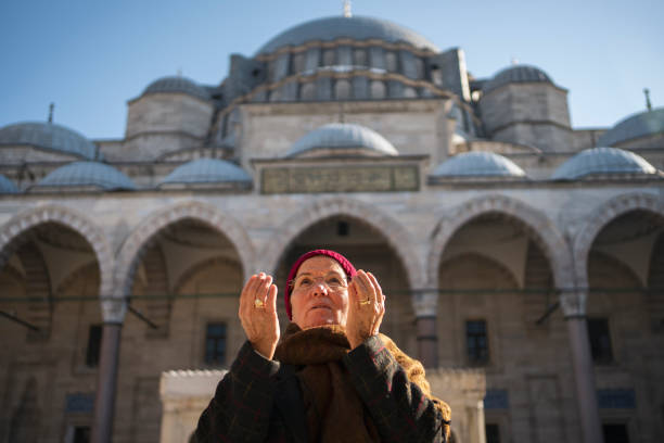 Woman praying near a mosque