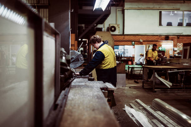 istock Blue collar workers in industry - grinding and cutting metal bars 1203785731