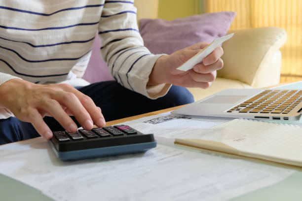 istock Selective focus of Man using laptop, holding invoice and check his salary for plan personal expense budget. Individual balance sheet for saving and payment control. Financial and economy concept. 1203786062