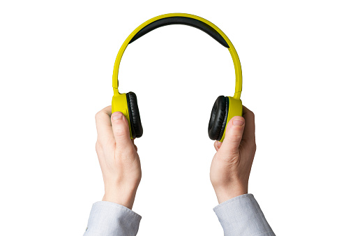 Man in shirt hold a pair of yellow headset earphones on white background
