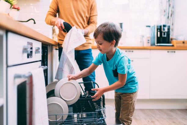 hijo ayudando a papá con el lavaplatos. concepto chores - task fotografías e imágenes de stock