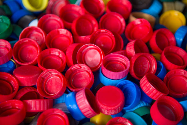 istock Plastic bottle caps background. Cap material is recyclable.Remove lids from plastic bottles before recycling them. Recycling collection and processing plastic bottle caps 1203795744