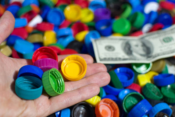 istock Colored plastic bottle caps and Dollars. Make money on Recycling Plastic, Bottles, Caps, PET, landfills 1203795768