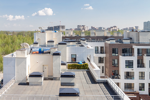 Flat roof with air conditioners on top modern apartment house building exterior mixed-use urban multi-family residential district area development.