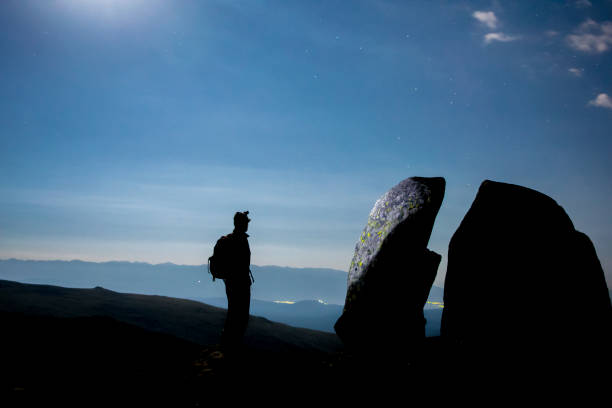 istock Silluette of a Man, Standing Next to a Large Rock, Split in Two 1203796549