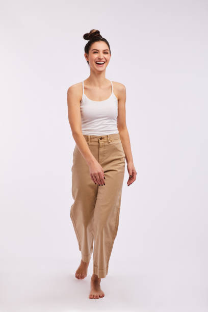 istock Laughing young woman walking against a gray background 1203796742