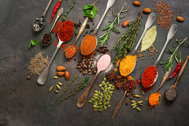 istock Assorted different bright colored spices, herbs, seasonings and seeds in spoons on a dark vintage background. Top view, flat lay, corner frame. 1203796793