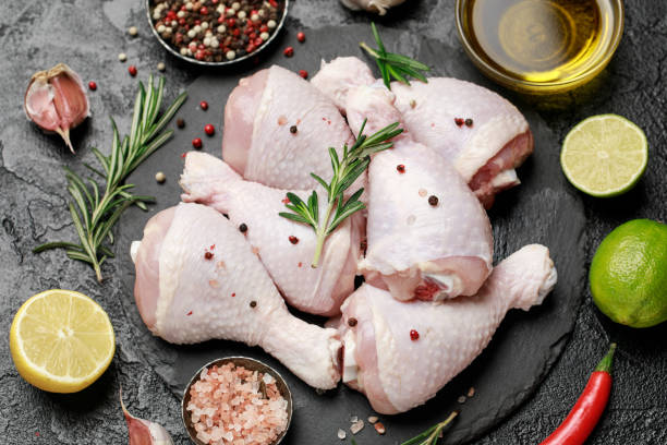 istock Raw uncooked chicken legs with spices and ingredients for cooking on cutting board 1203799808