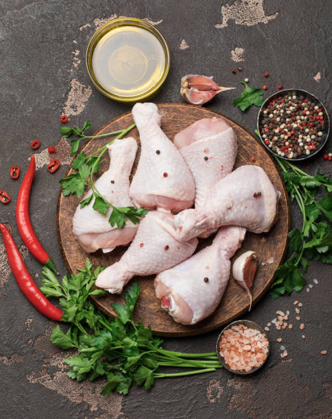 istock Raw uncooked chicken legs with spices and ingredients for cooking on cutting board 1203799873