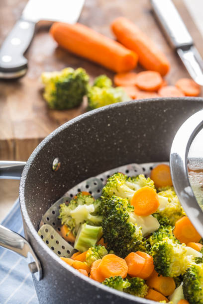 istock Steamed mixed vegetable in black pot. Healthy vegetable concept 1203799982
