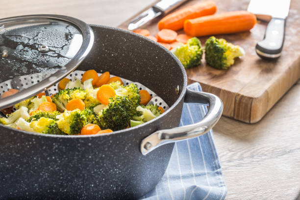 istock Steamed mixed vegetable in black pot. Healthy vegetable concept 1203799983