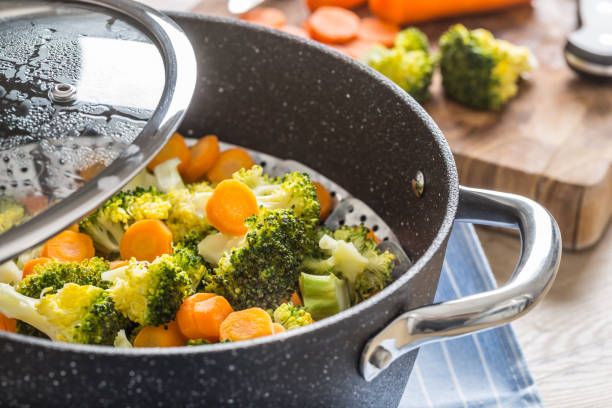 istock Steamed mixed vegetable in black pot. Healthy vegetable concept 1203800020