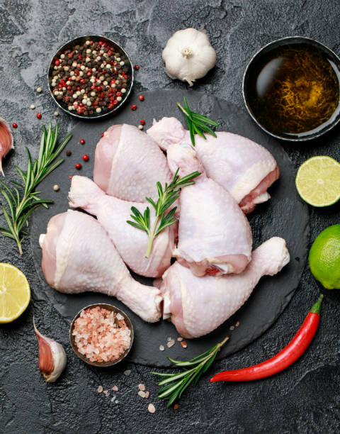 istock Raw uncooked chicken legs with spices and ingredients for cooking on cutting board 1203800030