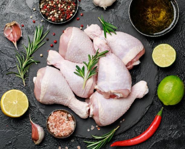 istock Raw uncooked chicken legs with spices and ingredients for cooking on cutting board 1203800078