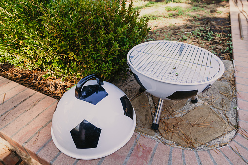 Football picnic. The original brazier in the form of a soccer ball stands on brickwork in the yard