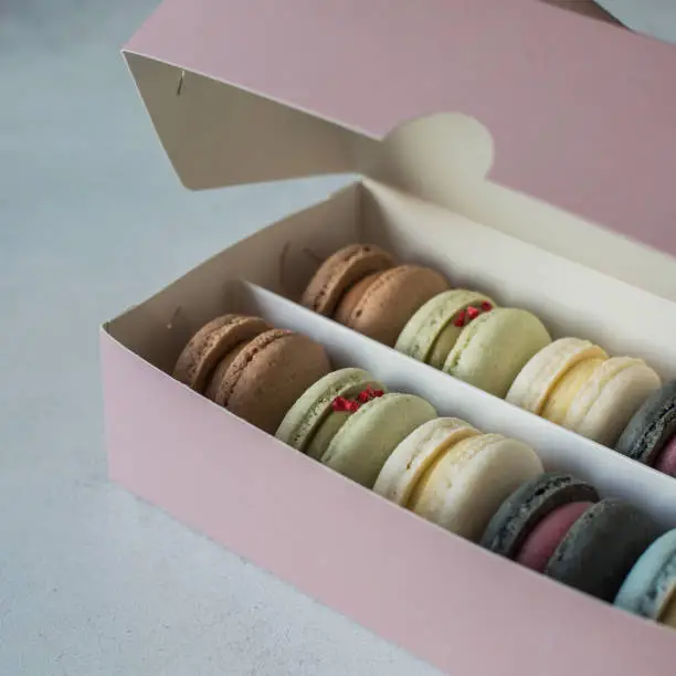 A half-closed box of pastel-colored macaroons.