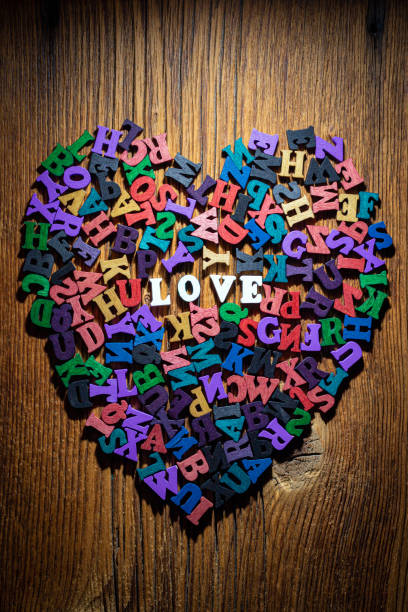 Heart of letters on an old wooden board. - fotografia de stock