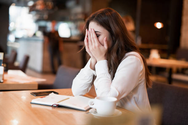 istock young woman in white jacket working outside office during lunch break looking exhausted drinking hot coffee in the trendy cafe multitasking modern businesswoman 1203803309