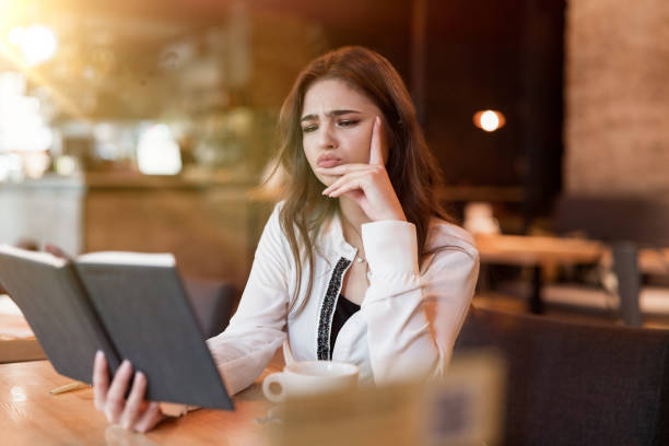 istock young beautiful woman in white jacket checking her planner working outside office drinking hot coffee in the trendy cafe looking frustrated multitasking modern businesswoman 1203803312