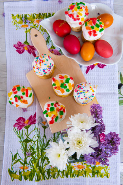 istock Easter cake. Traditional mini muffin with easter decoration on a wooden board. Easter eggs and flowers of lilac 1203803719