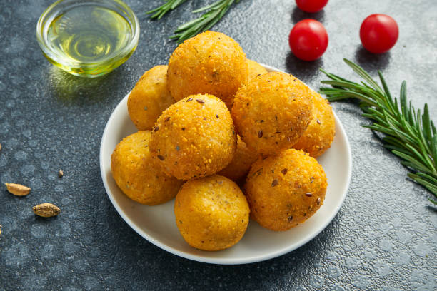 Deep-fried mozzarella cheese balls on a white plate on a black background. Tasty beer snack stock photo