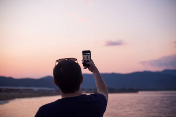 istock Young man taking a selfie on a beach 1203805947