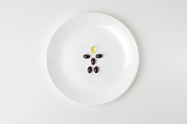 istock Astaxanthin and fish oil pills form a human shape 1203806303