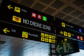 Information panel with No drone flying warning sign on it at an international airport.