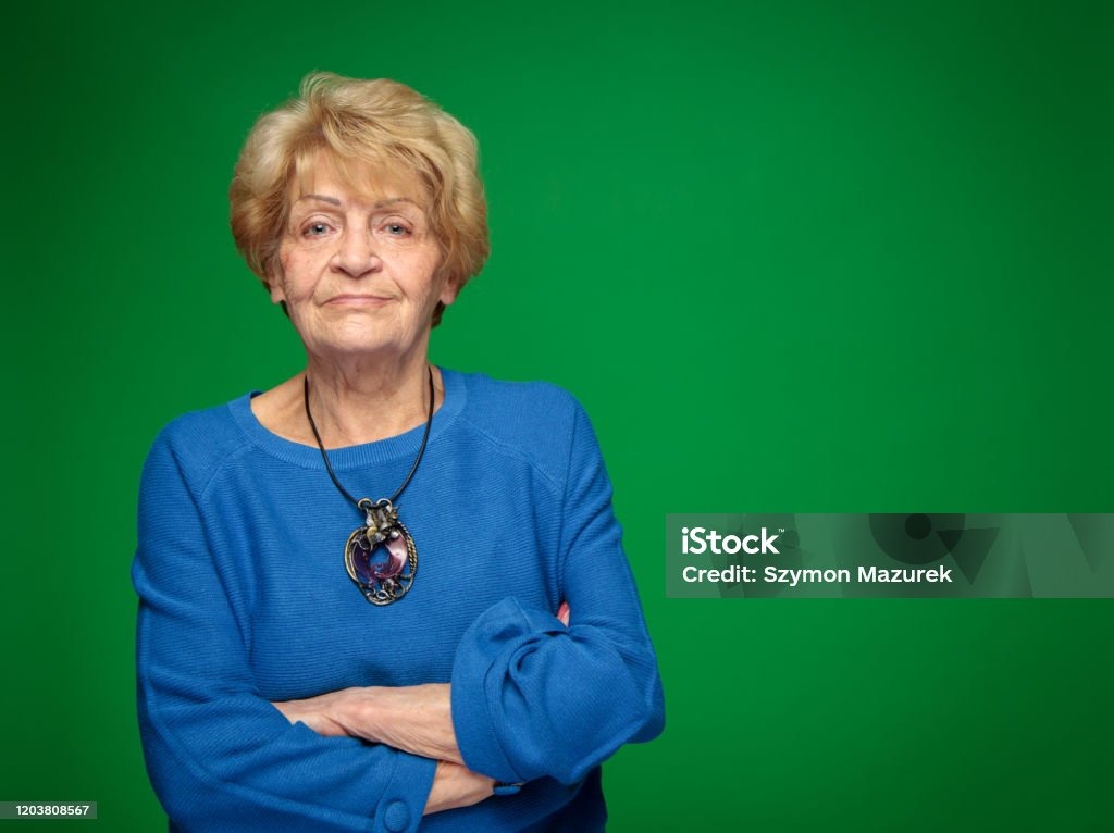 confident and powerful old lady Confident and powerful old lady. Studio shot on green background. Women Stock Photo