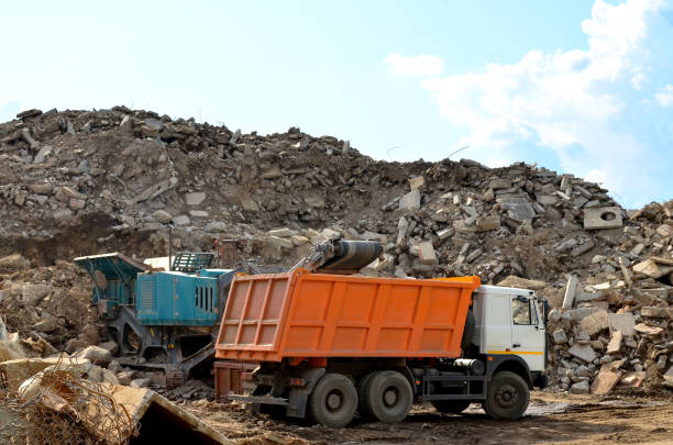 istock Excavator loads construction waste into reinforced concrete mobile shredder for crushing, recycling of construction mixed waste 1203808626