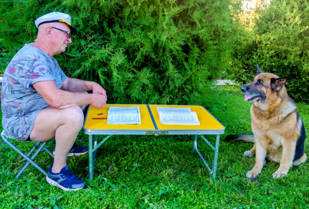 hombre perro hablando lectura - newspaper dog pets grass fotografías e imágenes de stock