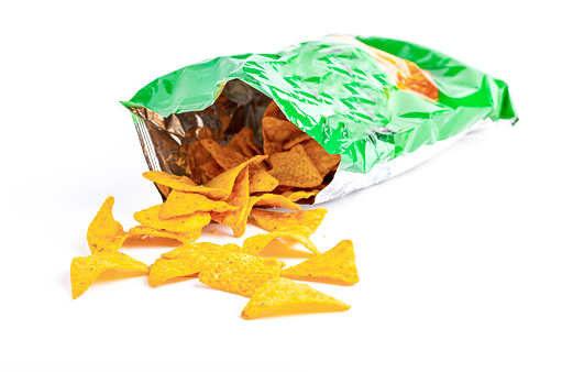 Heap of open packages and corn chips on a white background
