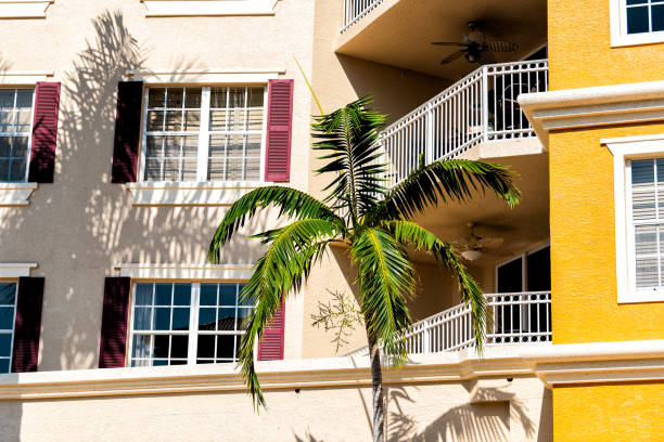 フロリダのコンドミニアムカラフルな黄色の多色の建物は、窓、ヤシの木、不動産プロパティスペイン建築と外観をファサード - florida naples florida house residential structure ストックフォトと画像