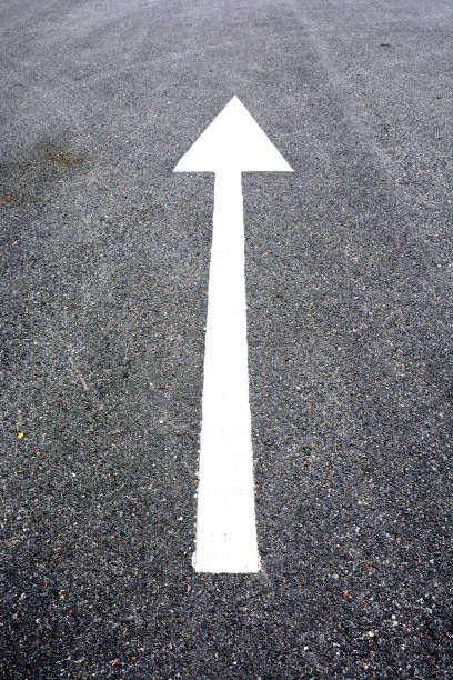 istock white arrow sign on the dry soil, ground, background 1203810287